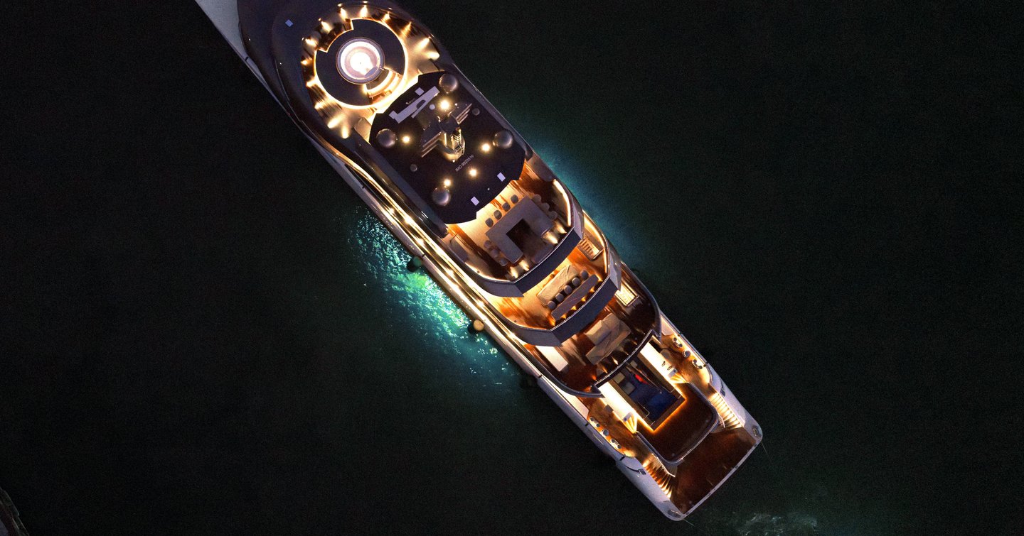 Aerial view of Superyacht Pangea at night with underwater lights