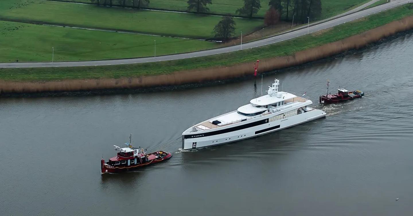 Feadship superyacht Graycliffs between tugboats in Dutch countrysides