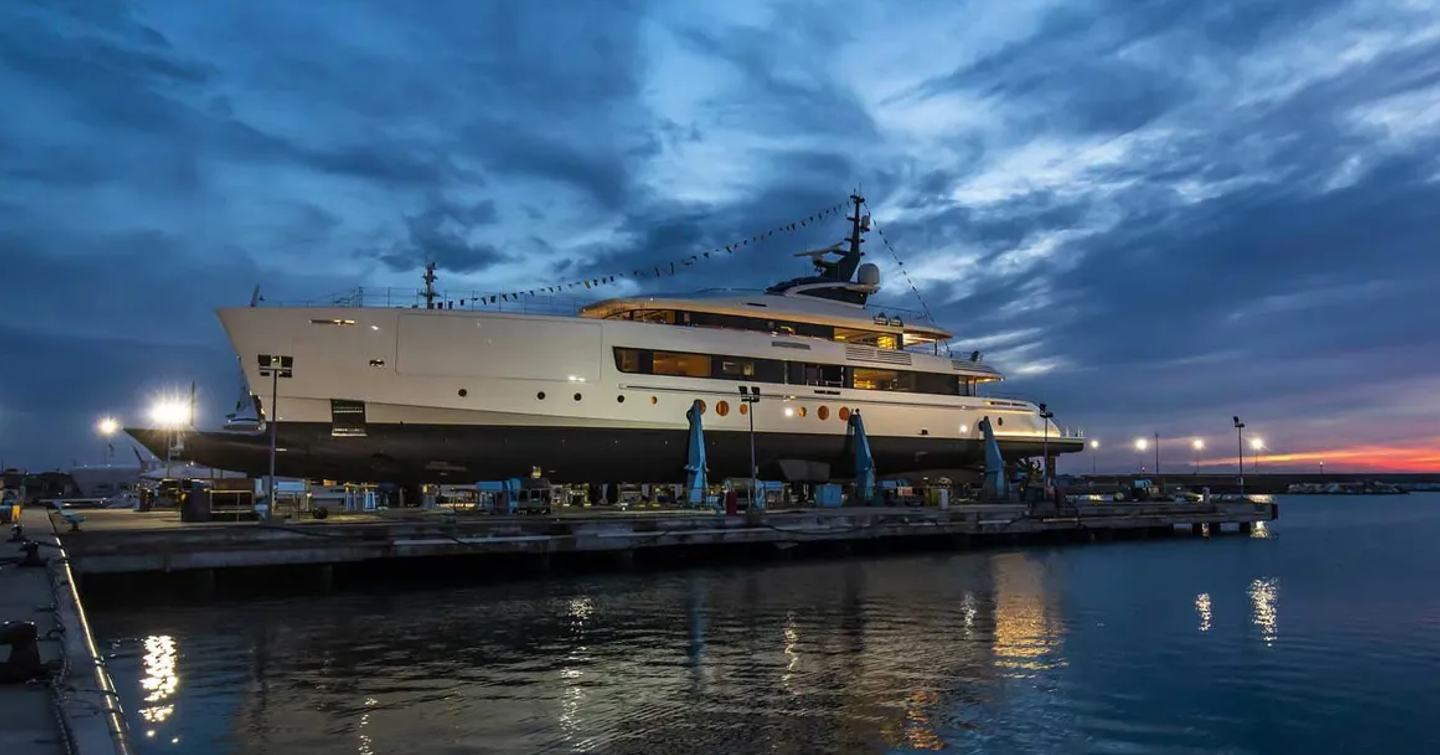 Benetti FB283 docked at dawn at Livorno facility. Adorned with flags for launch ceremony.