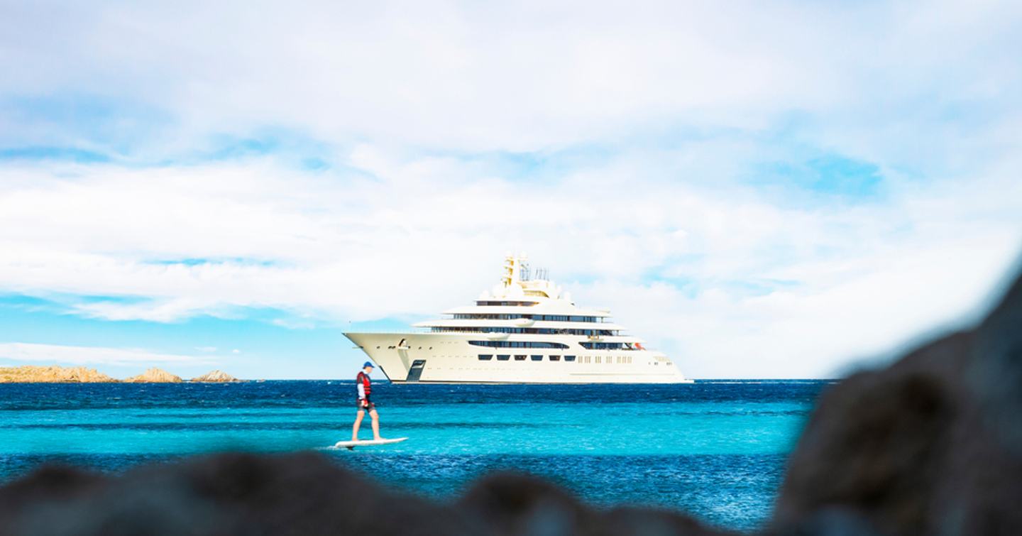 Superyacht at anchor with man using water toy 