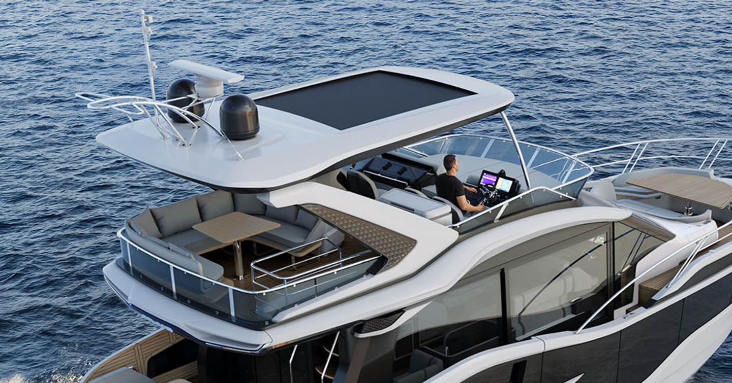 Galeon 520 Fly motor yacht flybridge with man at helm station