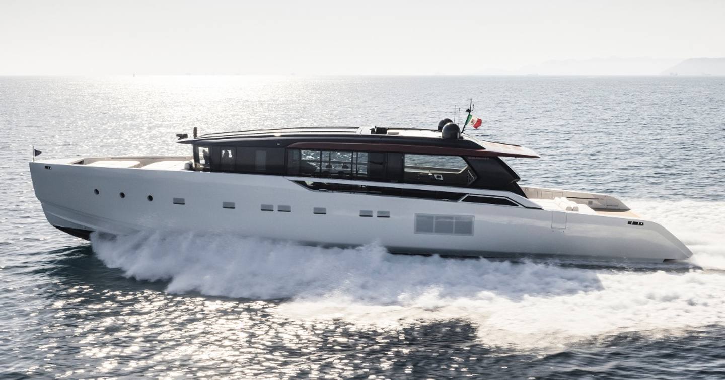 A port-side view of the Sanlorenzo SP110 charging through a flat sea, creating a wake