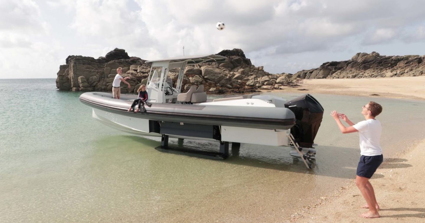 Family on amphibious tender in very shallow water on beach, with man on beach and ball being thrown to him