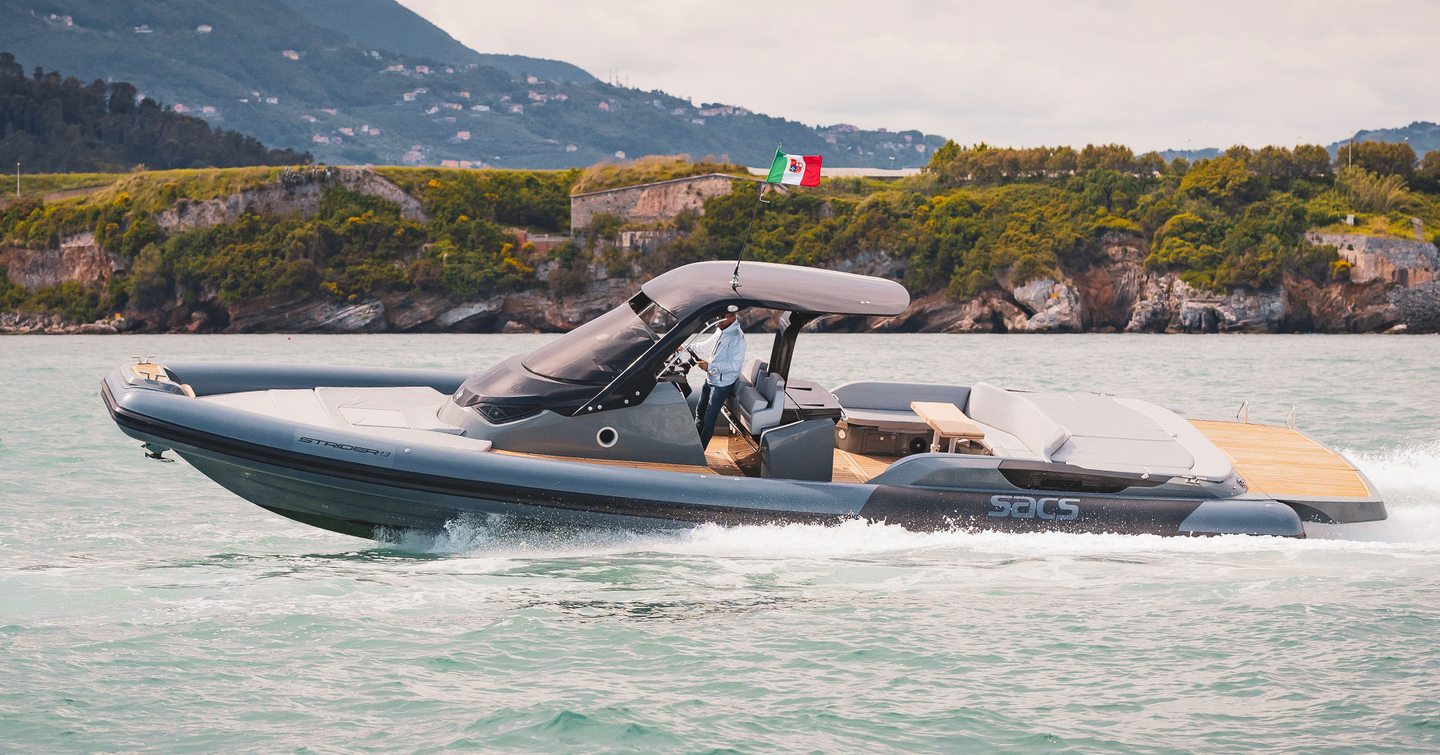 Sacs Tecnorib new Strider 13 running shot taken from water level towards port bow and side profile, moderate sea and land in background