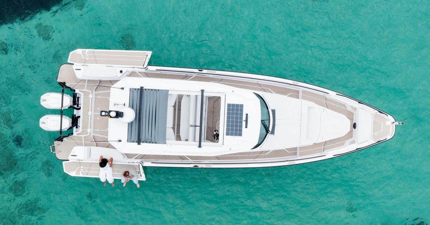 Aerial view of Axopar 38 Sun Top boat at anchor on calm blue water