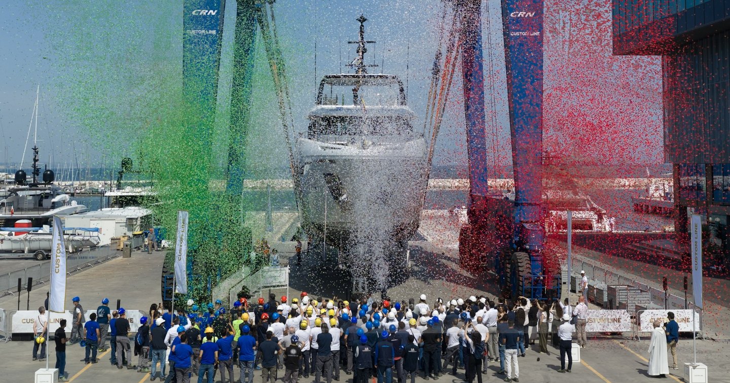 Custom Line Navetta 35 superyacht at launch with team in front of bow and green and red confetti
