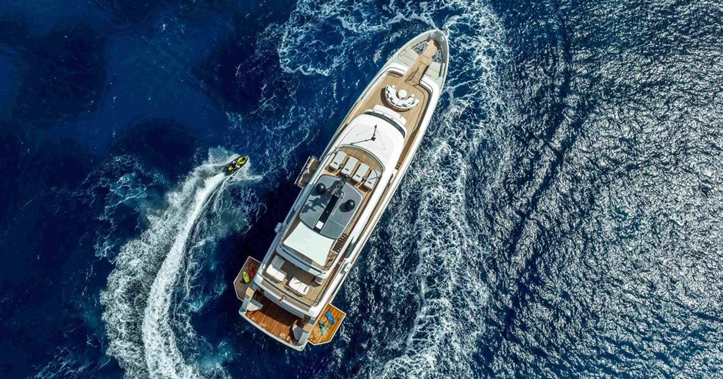Aerial view of Superyacht Unique S with tender circling 