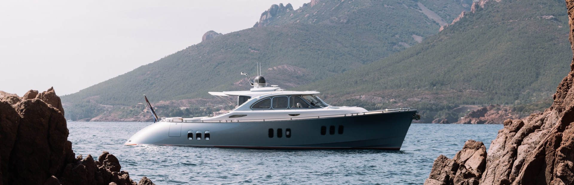 Zeelander yacht in water with rocky outcrop in foreground