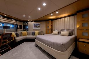 Superyacht Serenity II guest cabin with bed and lounge area