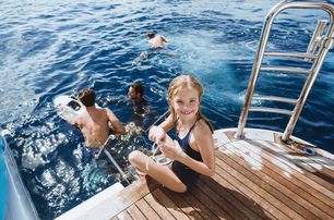 family fun swimming off back of boat