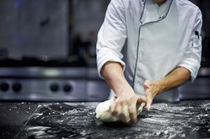 Superyacht chef kneading dough for fresh bread onboard