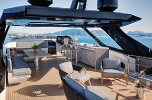 Sunseeker 94 Yacht sky deck lounging area and salon with bar, free standing furniture, sun creating shadow, looking forward from port quarter 