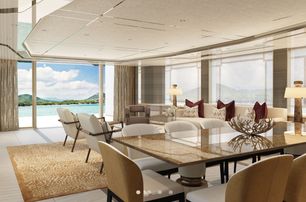 glossy dining table surrounded by chairs forward of a cream lounge area in the main salon of the Amels 60 yacht