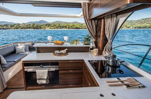 Marex 440 boat interior galley on port side looking aft towards open cockpit and water on bright day