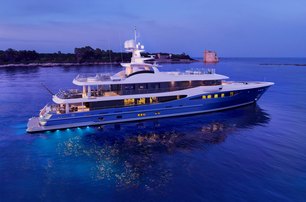 Amels 180 at dusk lights hitting the water