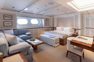 Double bed and sofas and tables in cabin on explorer yacht Blue II