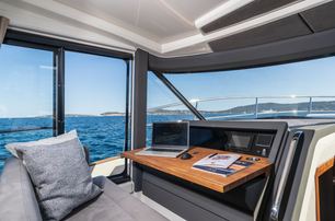 Marex 440 internal helm office area port side of the boat, looking out though open windows to bright day outside