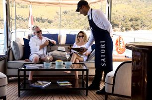 yacht crew steward pouring champagne for guests