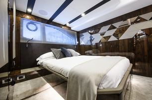 bed with white linen, high-gloss brown wall panels and cream carpets in the master suite on board the Targa 45 yacht