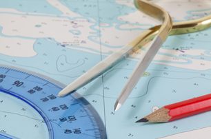 blue nautical chart with plotter, dividers and pencil