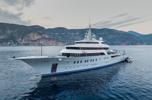 Superyacht VICTORIOUS underway with land in the distant background