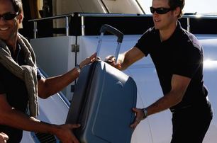 yacht crew assisting guest with luggage