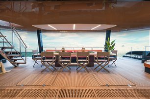 100 Sunreef Power shot from the interior looking out towards the dining area on the spacious aft deck, staircase to the left of the image, bright day beyond