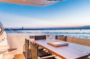 A dining table on the exterior of a Ferretti 670 superyacht.