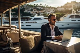 yacht charter manager on laptop in marina