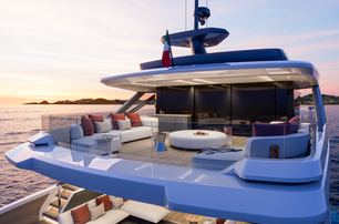 X100 Triplex by EXTRA Yachts  upper deck aft shown at sunset with seating, looking from starboard quarter almost diagonally across the deck forward