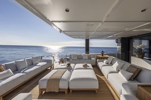 Arcadia A96 motor yacht aft deck exterior salon as sun is setting, ample sofas, looks very calm and relaxing