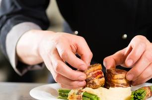 yacht chef in galley preparing dish