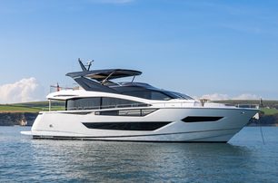 Sunseeker 88 Yacht anchored in calm waters, sunny day, starboard side from water level