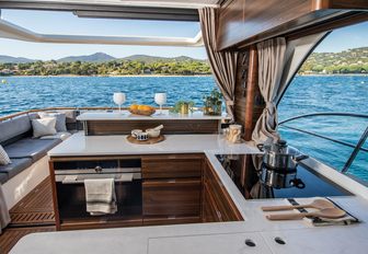 Marex 440 boat interior galley on port side looking aft towards open cockpit and water on bright day