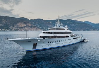 Superyacht VICTORIOUS underway with land in the distant background