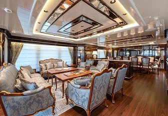 Interior lounge on Sanlorenzo Lady Lena superyacht, coffee table and seating in foreground with formal dining table in background