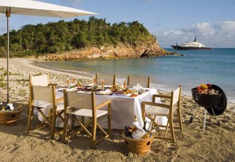 beach picnic set by interior yacht crew with yacht in background