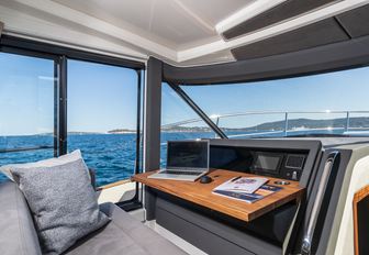 Marex 440 internal helm office area port side of the boat, looking out though open windows to bright day outside