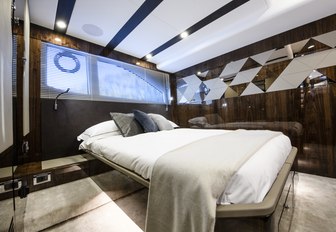 bed with white linen, high-gloss brown wall panels and cream carpets in the master suite on board the Targa 45 yacht