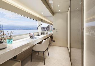 Office desk and chair onboard Arcadia A115, facing wide window overlooking sea