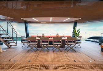 100 Sunreef Power shot from the interior looking out towards the dining area on the spacious aft deck, staircase to the left of the image, bright day beyond