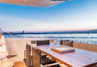 A dining table on the exterior of a Ferretti 670 superyacht.