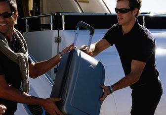 yacht crew assisting guest with luggage