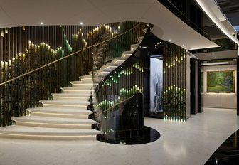 KISMETs grand staircase shown, white marble flooring, and stunning sweeping staircase, elements of tones of green