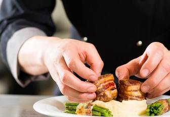 yacht chef in galley preparing dish