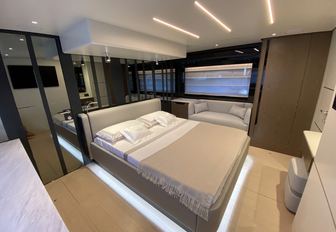 Sessa Marine F60 Flybridge cabin in muted tones, with ceiling light and under bed illumination, ecru carpet, large window in background