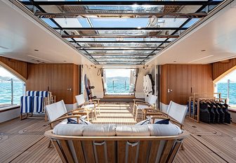 Beach club onboard Sanlorenzo Lady Lena, central director chair seating, with sunloungers port and starboard 