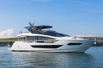 Sunseeker 88 Yacht anchored in calm waters, sunny day, starboard side from water level