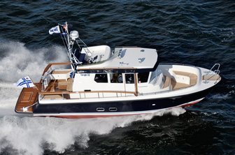 Targa 27.2 motor boat running shot aerial over starboard side over roof, underway at speed making wash, smooth sea