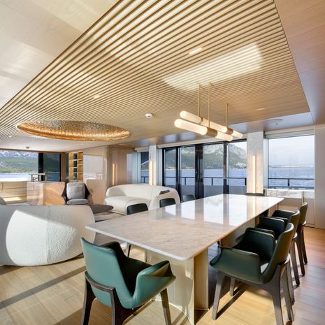 Alia Superyacht Ximena main saloon dining area with marbled dining table and green chairs 